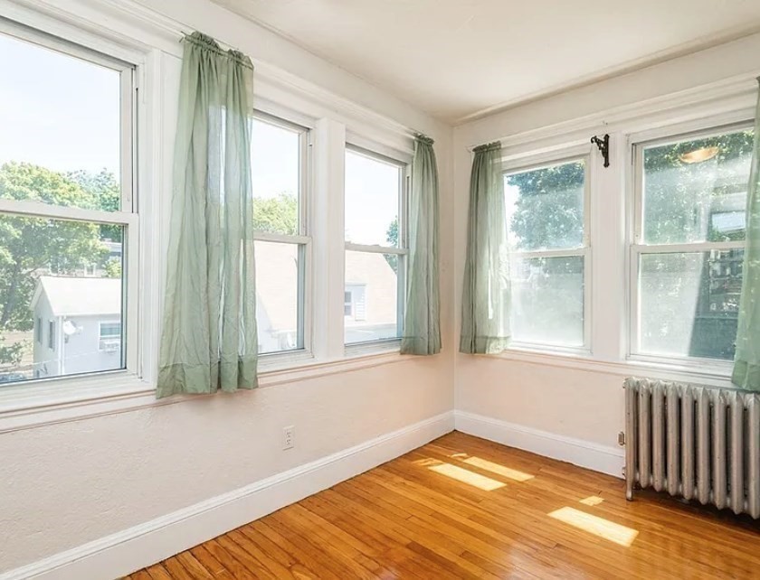 124 Selden Street Boston, MA 02124 - Photo 11 of 35 a view of empty room with wooden floor and fan