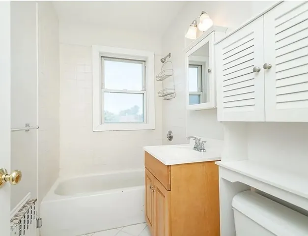 a bathroom with a sink a bathtub and a window