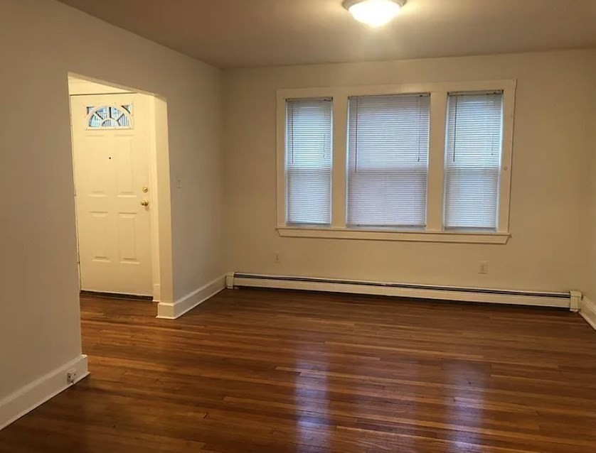 124 Selden Street Boston, MA 02124 - Photo 17 of 35 an empty room with wooden floor and windows