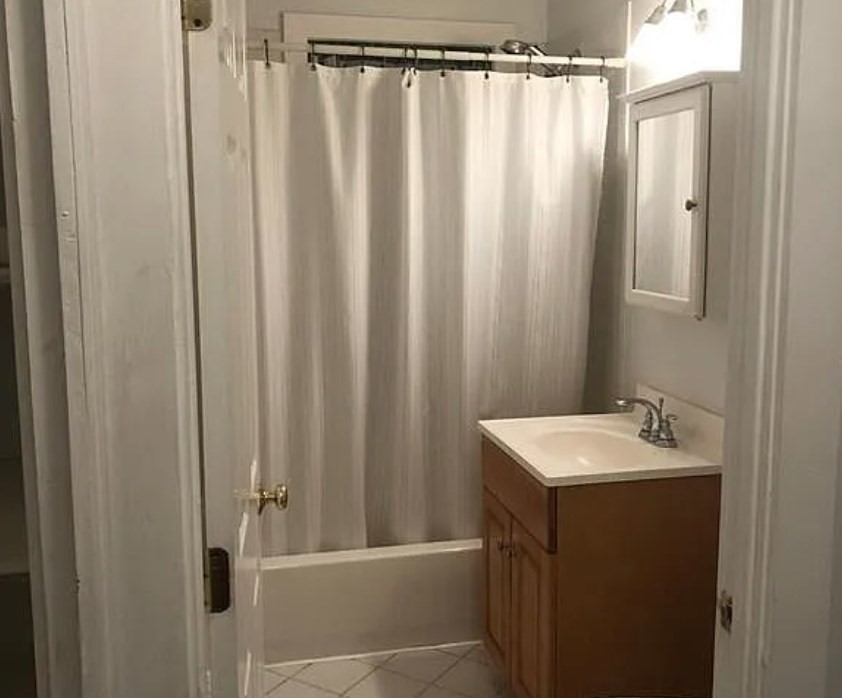 124 Selden Street Boston, MA 02124 - Photo 19 of 35 a bathroom with a sink a mirror and a shower curtain