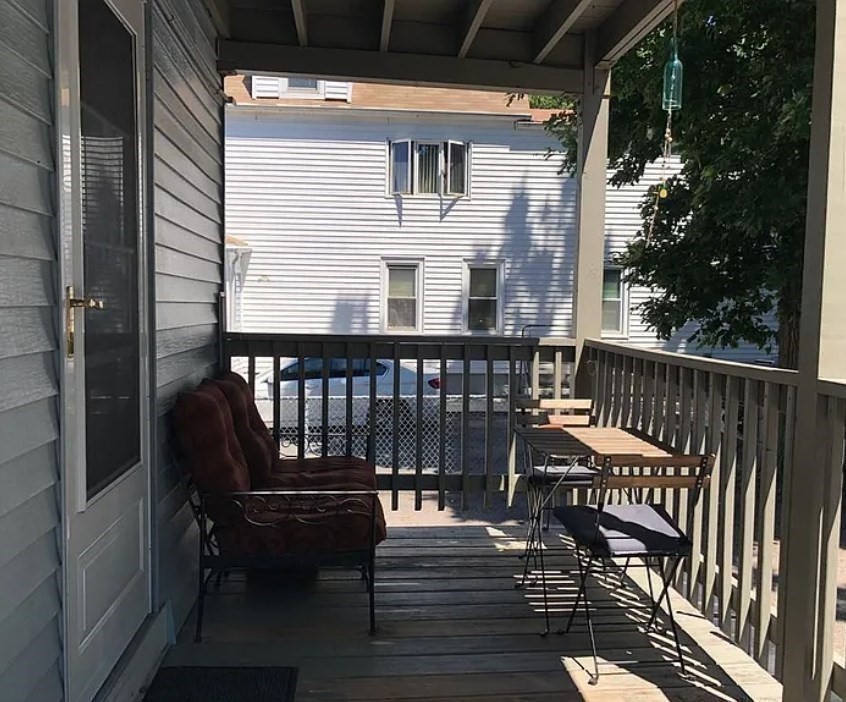 124 Selden Street Boston, MA 02124 - Photo 22 of 35 a balcony with wooden floor table and chairs