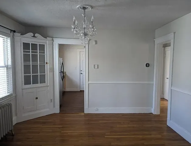 a view of a livingroom with wooden floor and windows