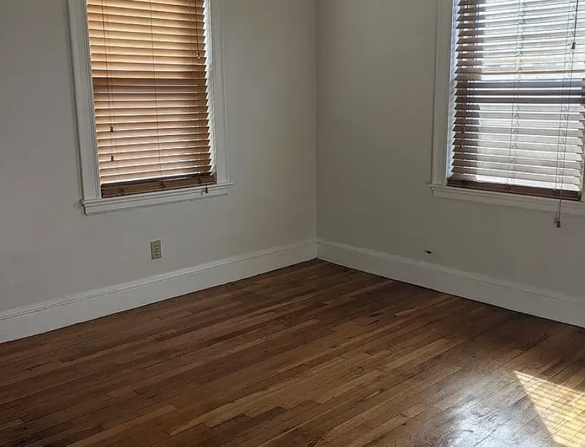 124 Selden Street Boston, MA 02124 - Photo 24 of 35 a view of an empty room with wooden floor and a window