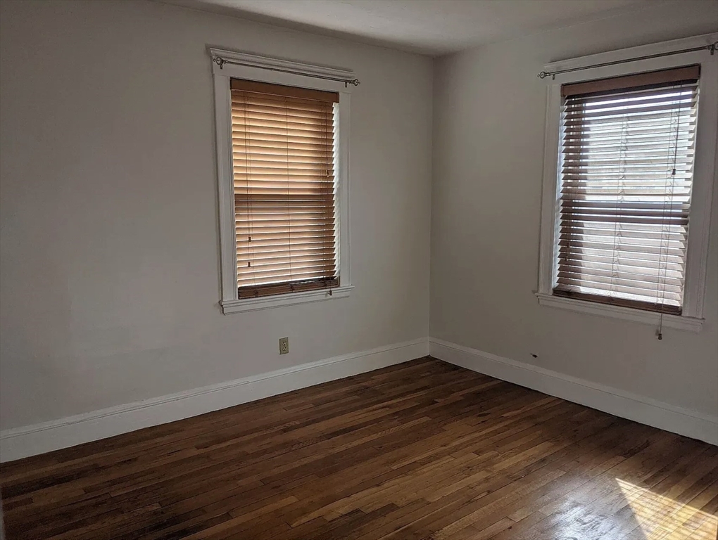 124 Selden Street Boston, MA 02124 - Photo 25 of 35 a view of an empty room with wooden floor and a window