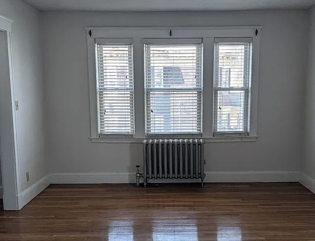 124 Selden Street Boston, MA 02124 - Photo 27 of 35 a view of an empty room with wooden floor and a window