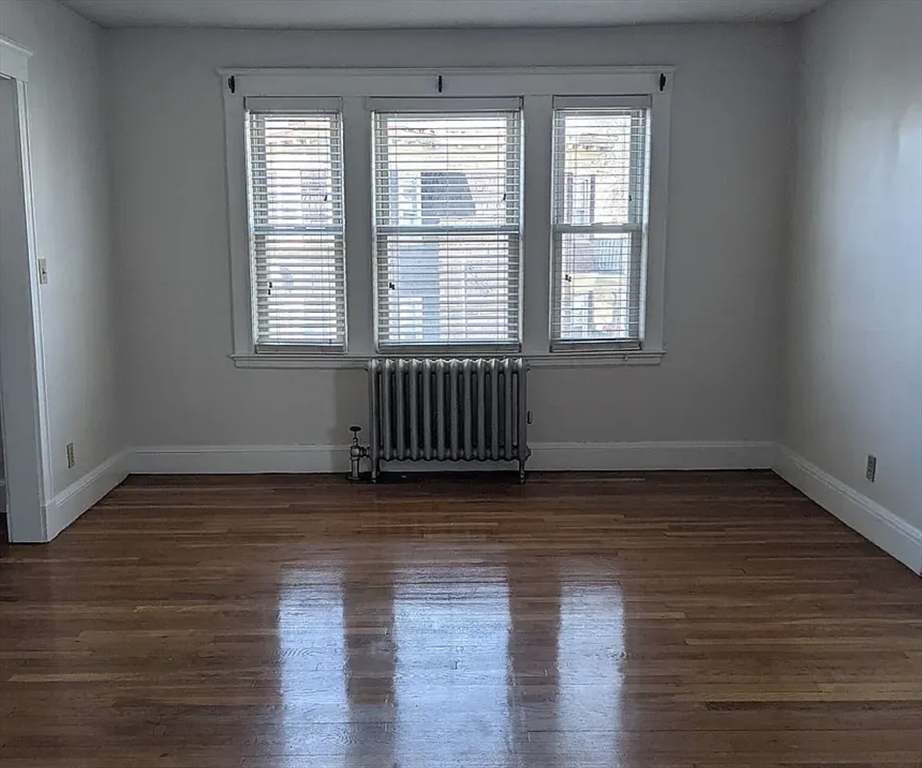 124 Selden Street Boston, MA 02124 - Photo 28 of 35 a view of an empty room with wooden floor and a window