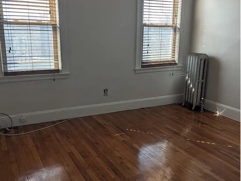 124 Selden Street Boston, MA 02124 - Photo 29 of 35 an empty room with wooden floor and windows