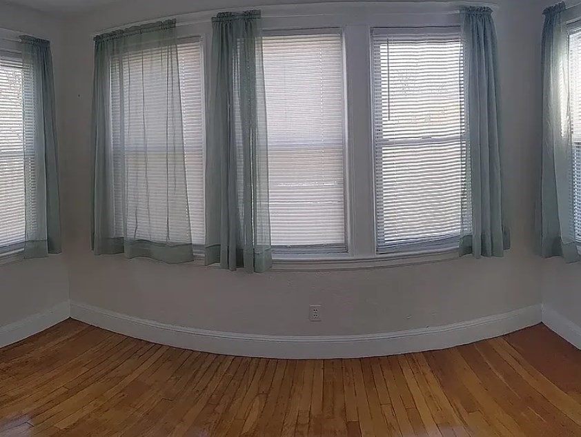 124 Selden Street Boston, MA 02124 - Photo 32 of 35 an empty room with wooden floor and windows
