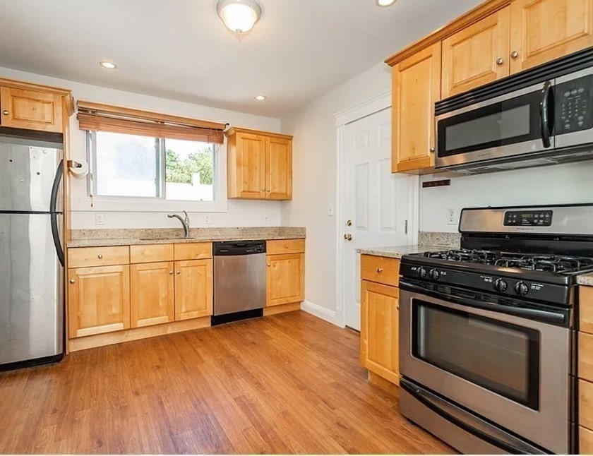 124 Selden Street Boston, MA 02124 - Photo 4 of 35 a kitchen with a stove a sink and a microwave
