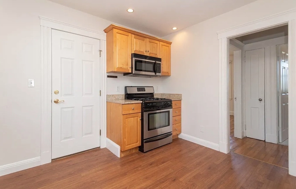 124 Selden Street Boston, MA 02124 - Photo 5 of 35 a kitchen with wooden floor and electronic appliances