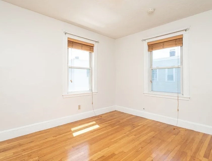 124 Selden Street Boston, MA 02124 - Photo 6 of 35 a view of empty room with wooden floor and fan