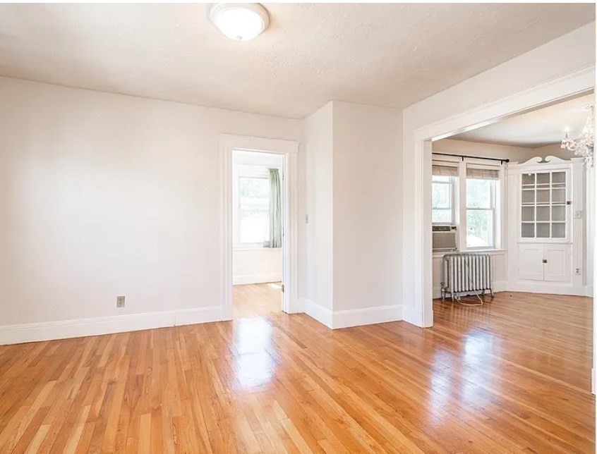 124 Selden Street Boston, MA 02124 - Photo 7 of 35 an empty room with wooden floor and windows