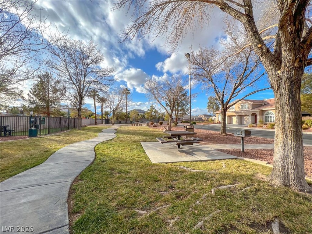 10148 Tree Bark Street Las Vegas, NV 89183 - Photo 32 of 37 A winding pathway leads through a serene park area with mature trees and a picnic spot.
