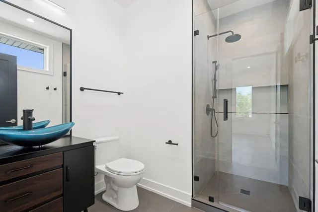 a bathroom with a granite countertop shower a toilet and a sink