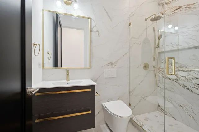 a bathroom with a sink a toilet and shower