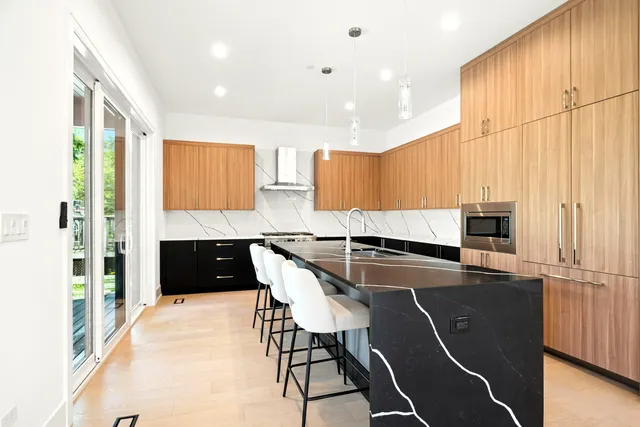 a kitchen with stainless steel appliances granite countertop a refrigerator a stove a sink and a stove