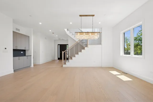 a view of empty room with a window and chandelier