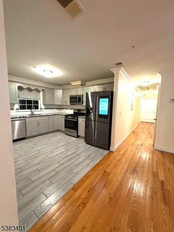 a large kitchen with kitchen island a sink dishwasher stove and oven with wooden floor