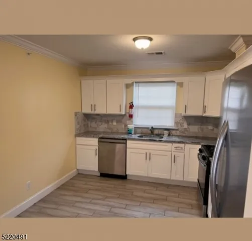 a kitchen with granite countertop a sink stove and refrigerator