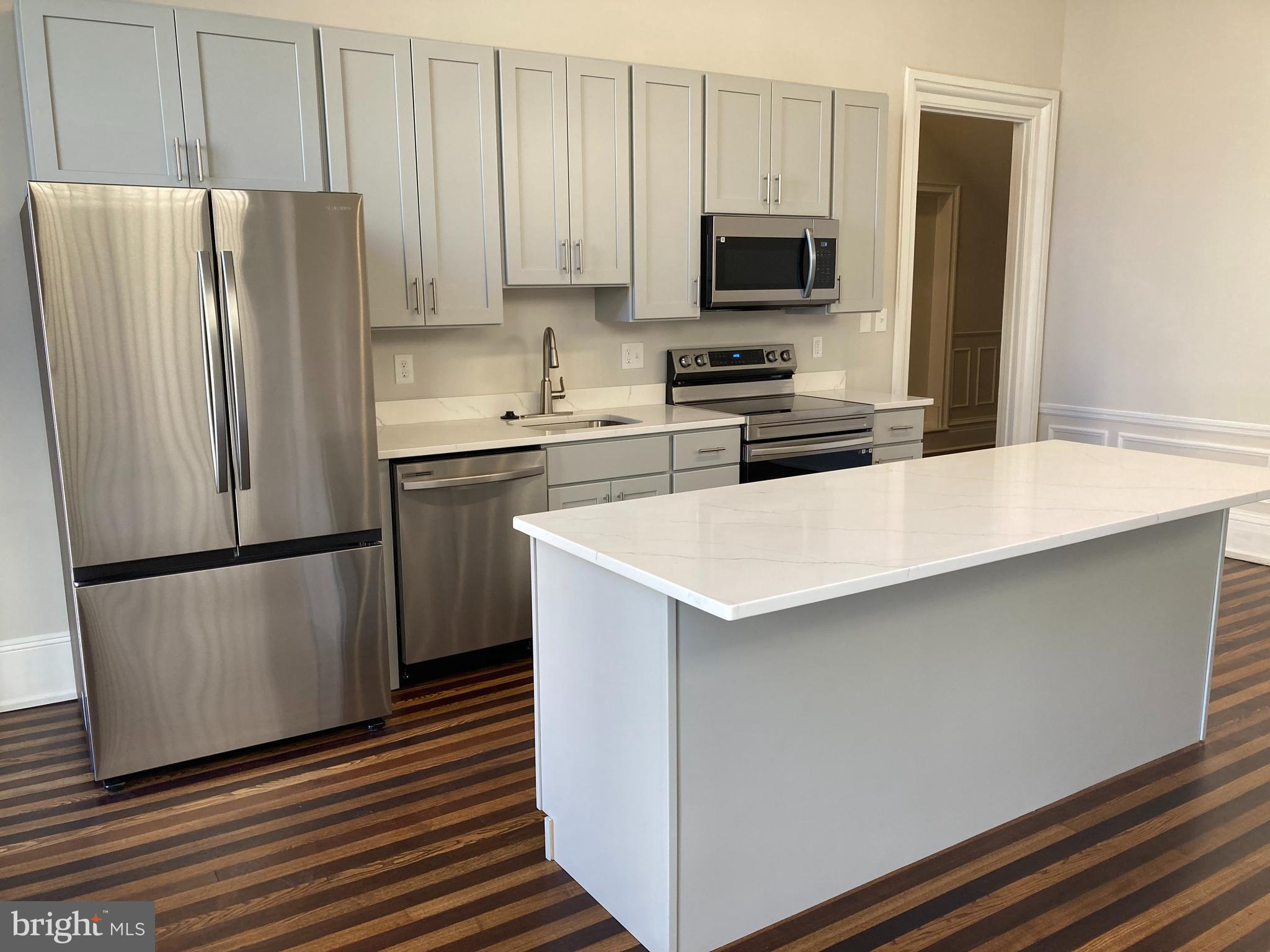 10 East Chase Street Baltimore, MD 21202 - Photo 2 of 60 a kitchen with stainless steel appliances a refrigerator a stove a microwave and a sink