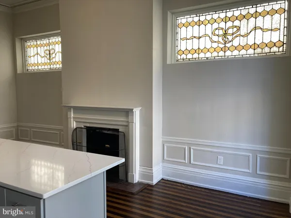 an empty room with wooden floor and window