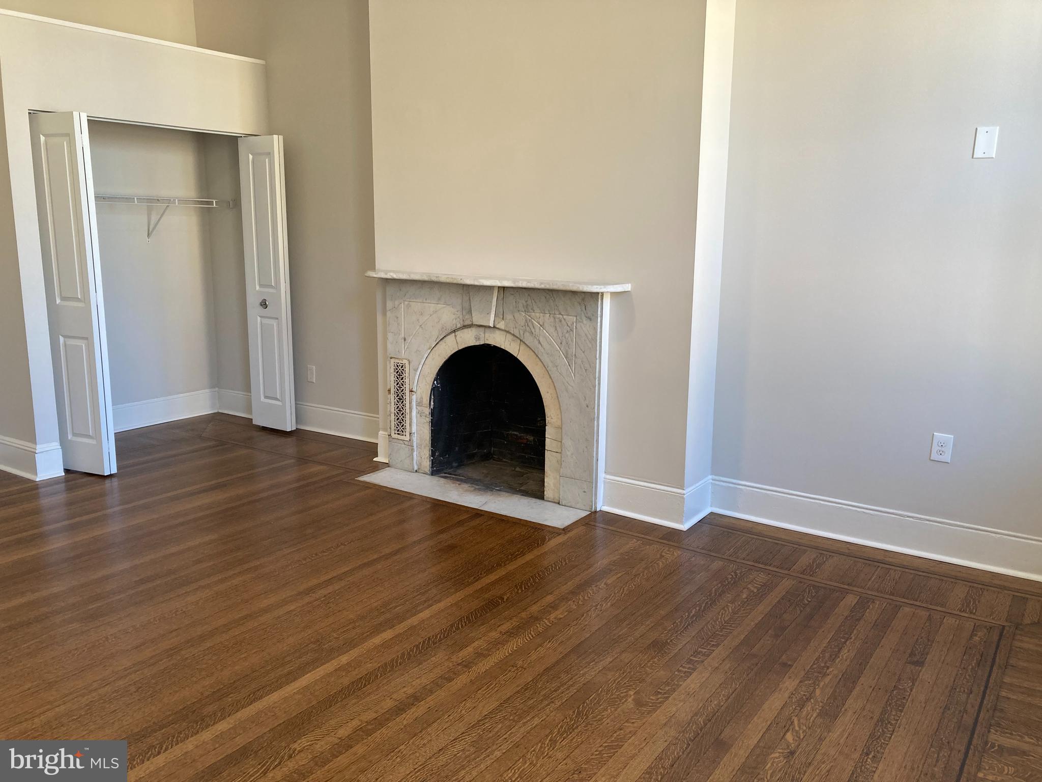 10 East Chase Street Baltimore, MD 21202 - Photo 25 of 60 a view of an empty room with wooden floor and a fireplace