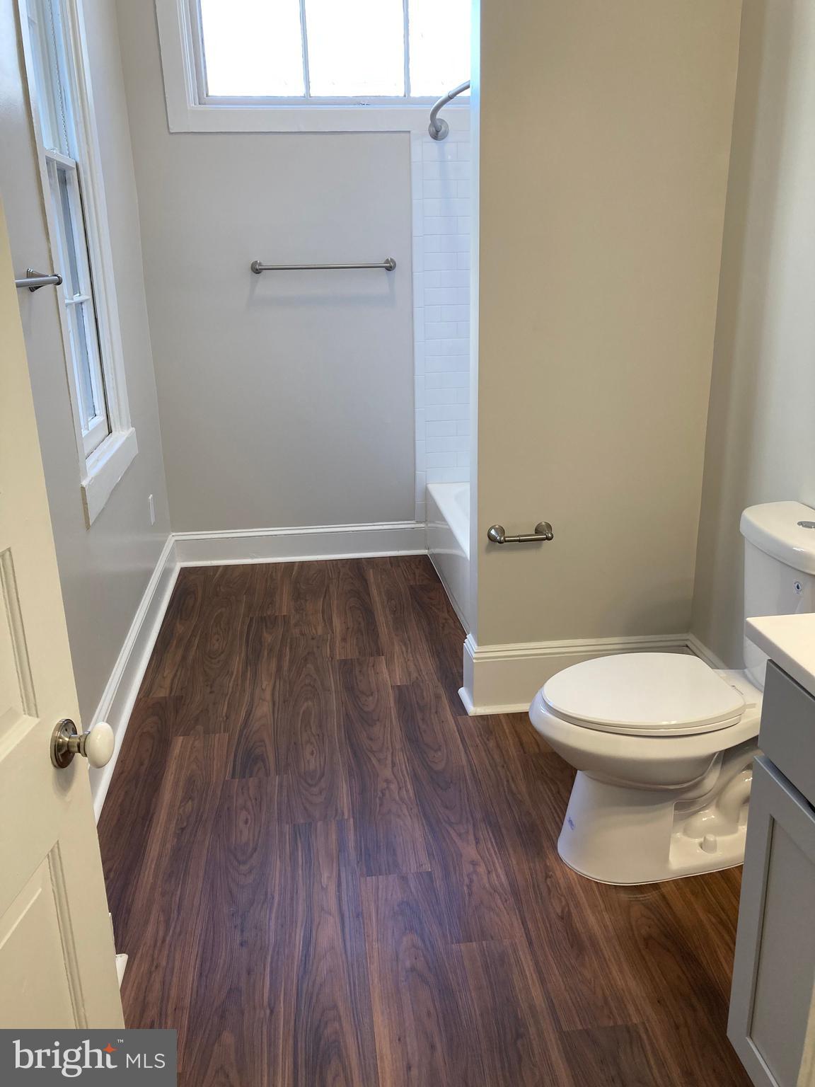 10 East Chase Street Baltimore, MD 21202 - Photo 38 of 60 a bathroom with a toilet and a wooden floor