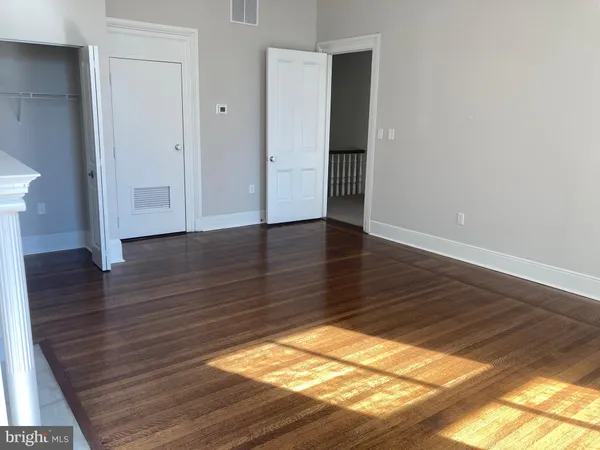 a view of an empty room with wooden floor