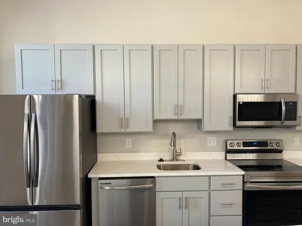 a kitchen with a sink stainless steel appliances and white cabinets