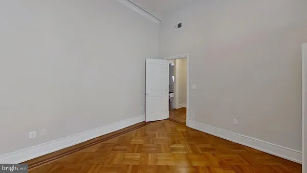 an empty room with wooden floor fireplace and windows
