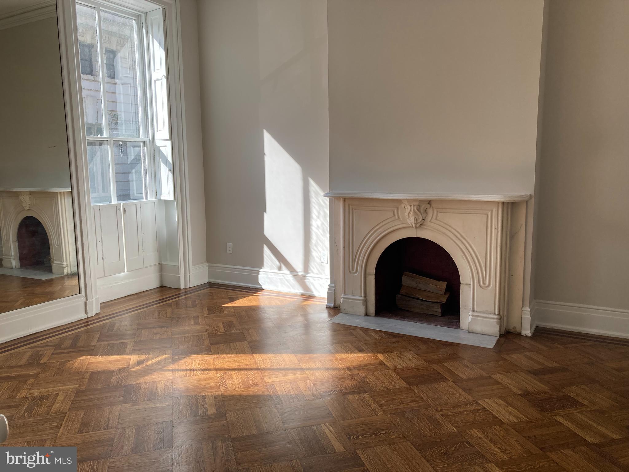 10 East Chase Street Baltimore, MD 21202 - Photo 8 of 60 an empty room with fireplace and windows