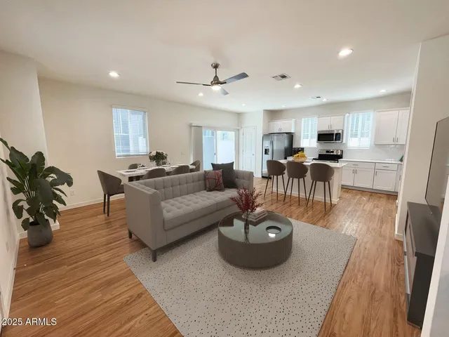 a living room with furniture and a wooden floor
