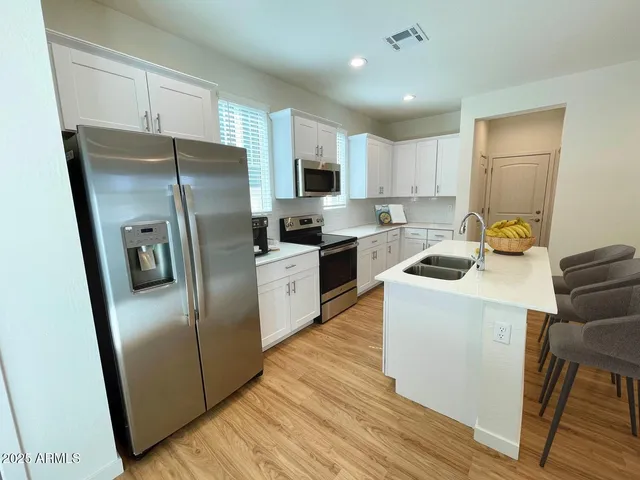 a kitchen with a refrigerator a sink and cabinets