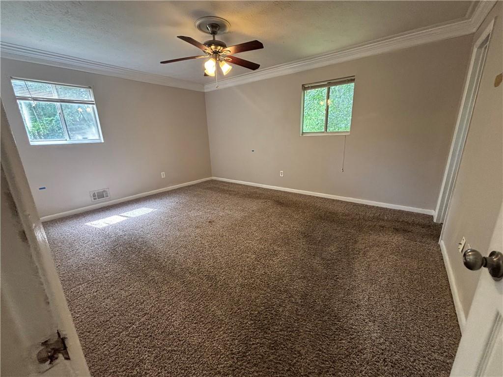 4135 Moore Road Conley, GA 30288 - Photo 6 of 10 an empty room with windows and fan