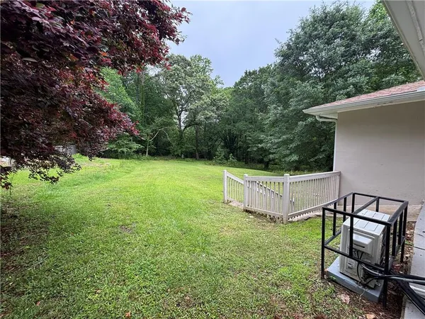 a view of backyard with wooden fence and a bench