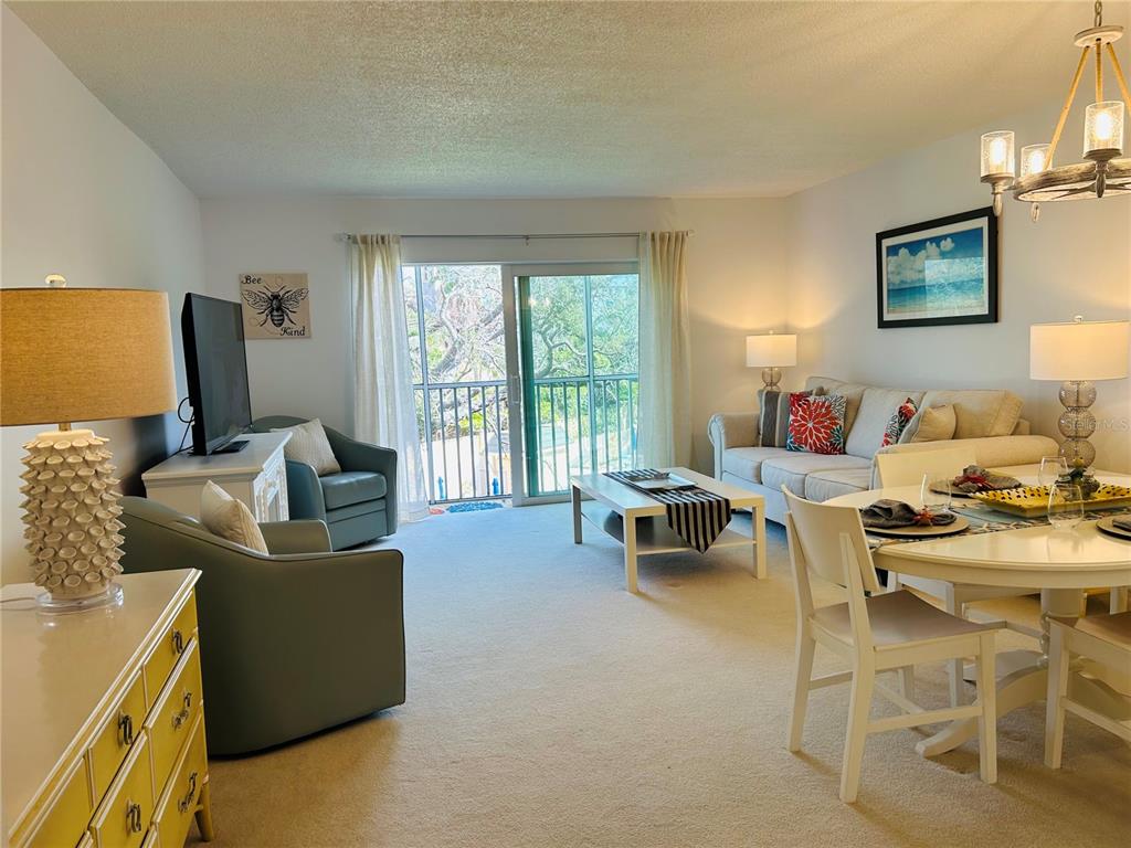 8625 Midnight Pass Road, Unit 305B Sarasota, FL 34242 - Photo 13 of 38 a living room with furniture and a flat screen tv