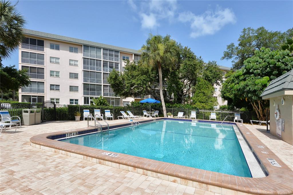8625 Midnight Pass Road, Unit 305B Sarasota, FL 34242 - Photo 16 of 38 a view of a swimming pool with sitting area