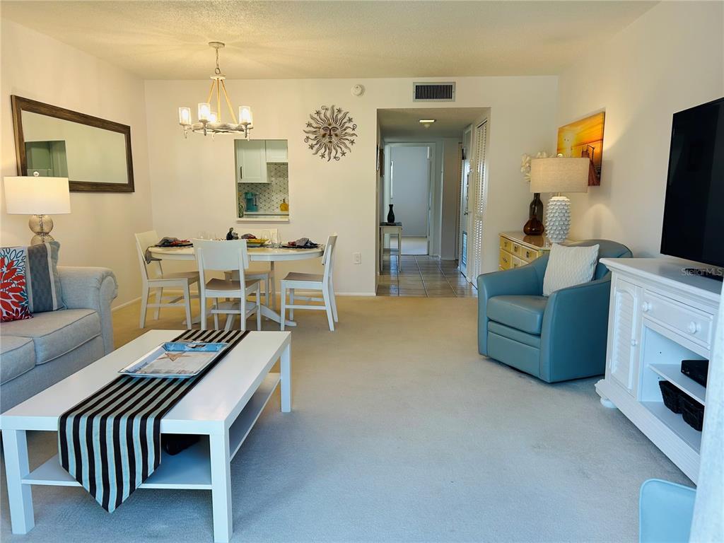 8625 Midnight Pass Road, Unit 305B Sarasota, FL 34242 - Photo 20 of 38 a living room with furniture a flat screen tv and kitchen view