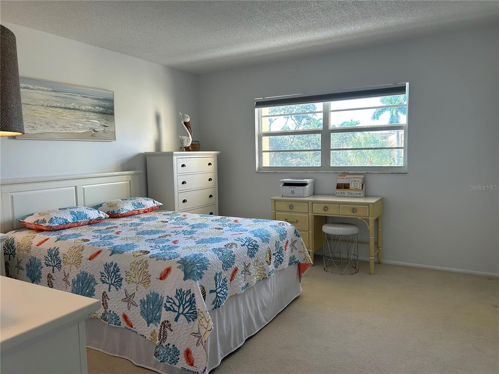 8625 Midnight Pass Road, Unit 305B Sarasota, FL 34242 - Photo 22 of 38 a bedroom with a bed and a table in it