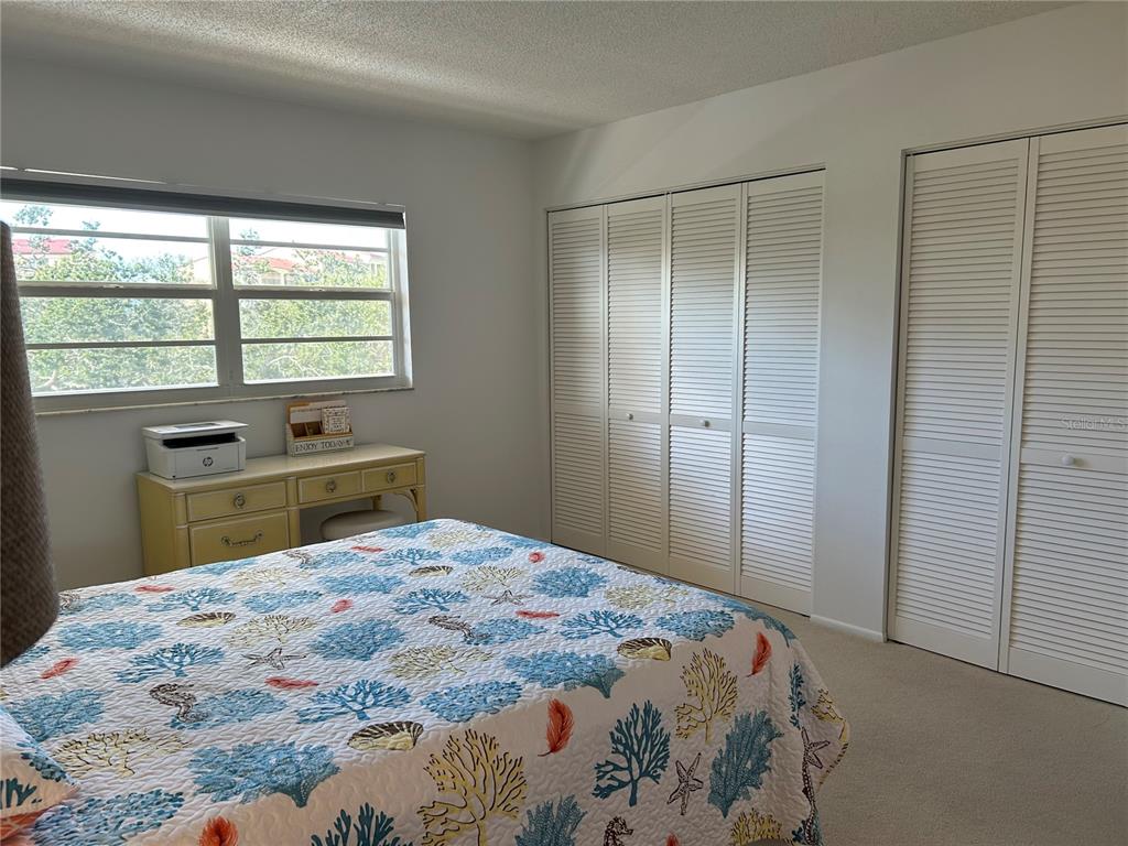 8625 Midnight Pass Road, Unit 305B Sarasota, FL 34242 - Photo 24 of 38 a bedroom with a bed and a window