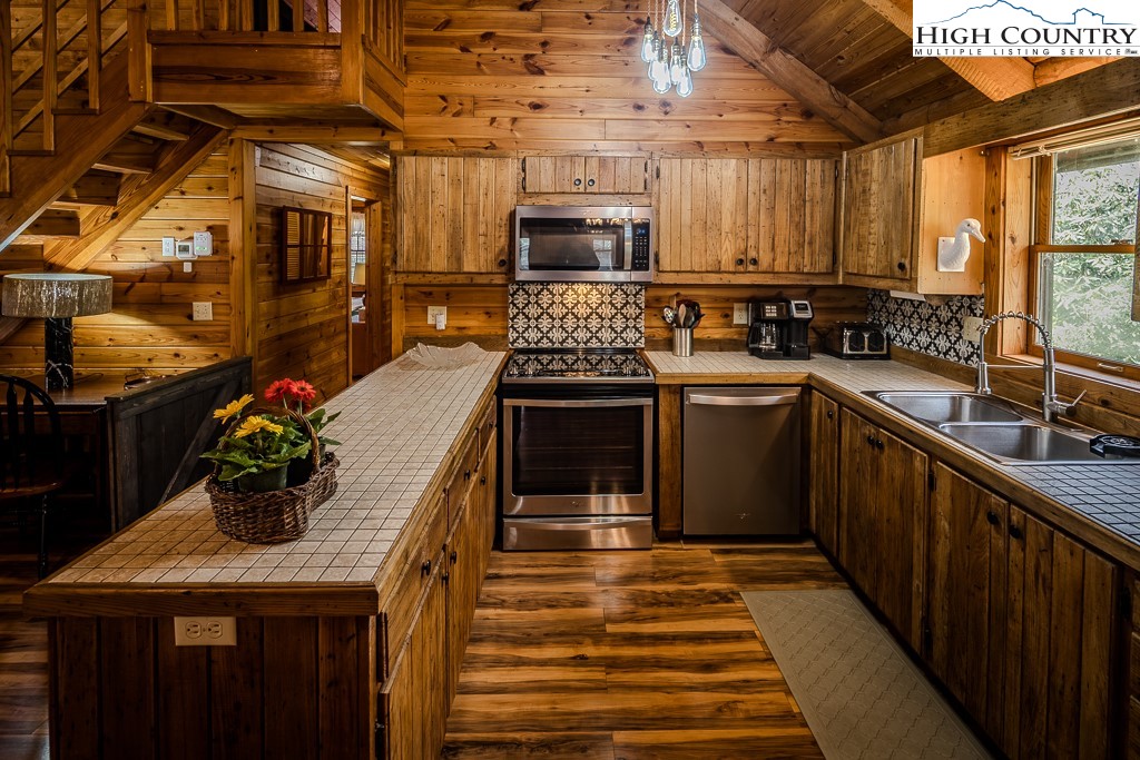 80 Avery Co High School Road Newland, NC 28657 - Photo 7 of 36 a kitchen with stainless steel appliances granite countertop a sink a stove and a wooden floors