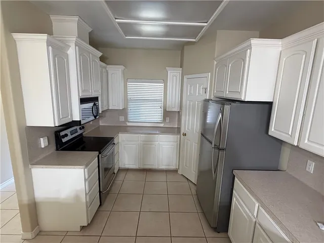 a kitchen with a sink a refrigerator and cabinets