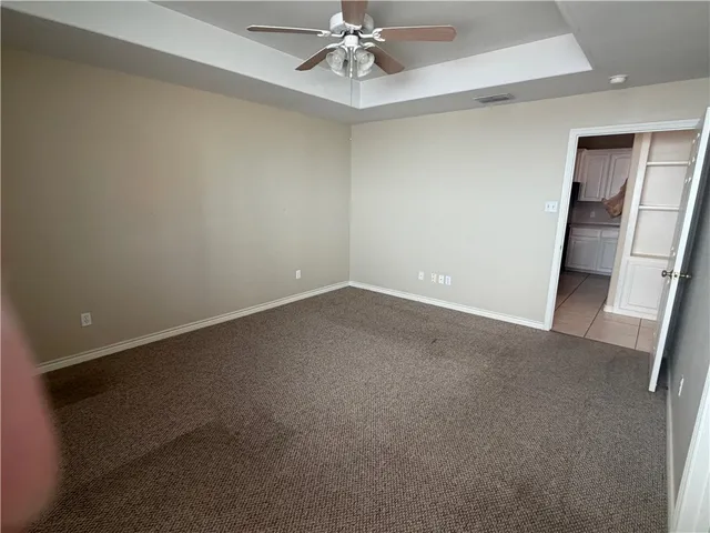 en empty room with windows and ceiling fan