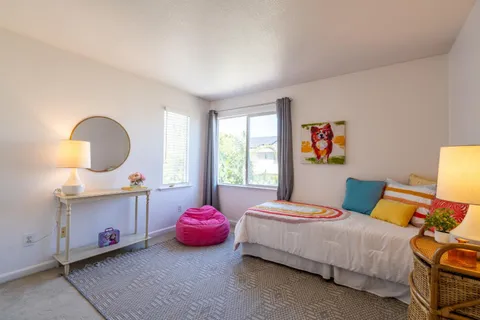 a bedroom with a bed and a lamp on dresser