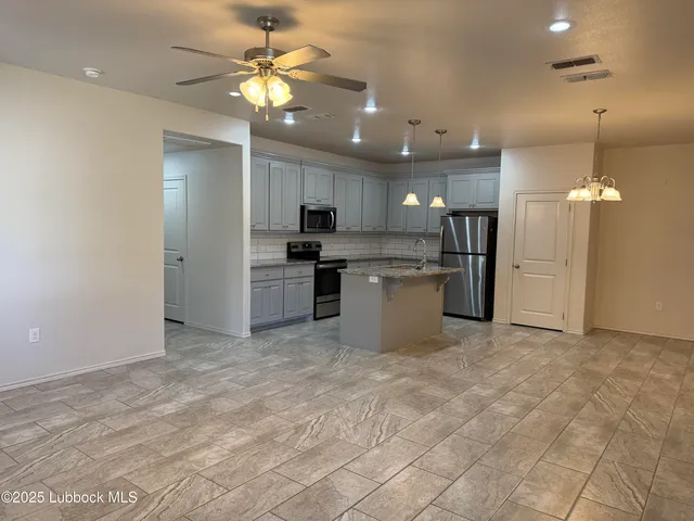 a view of a kitchen with a sink and a refrigerator