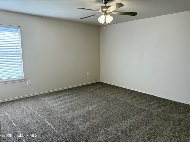 an empty room with a window and a fan