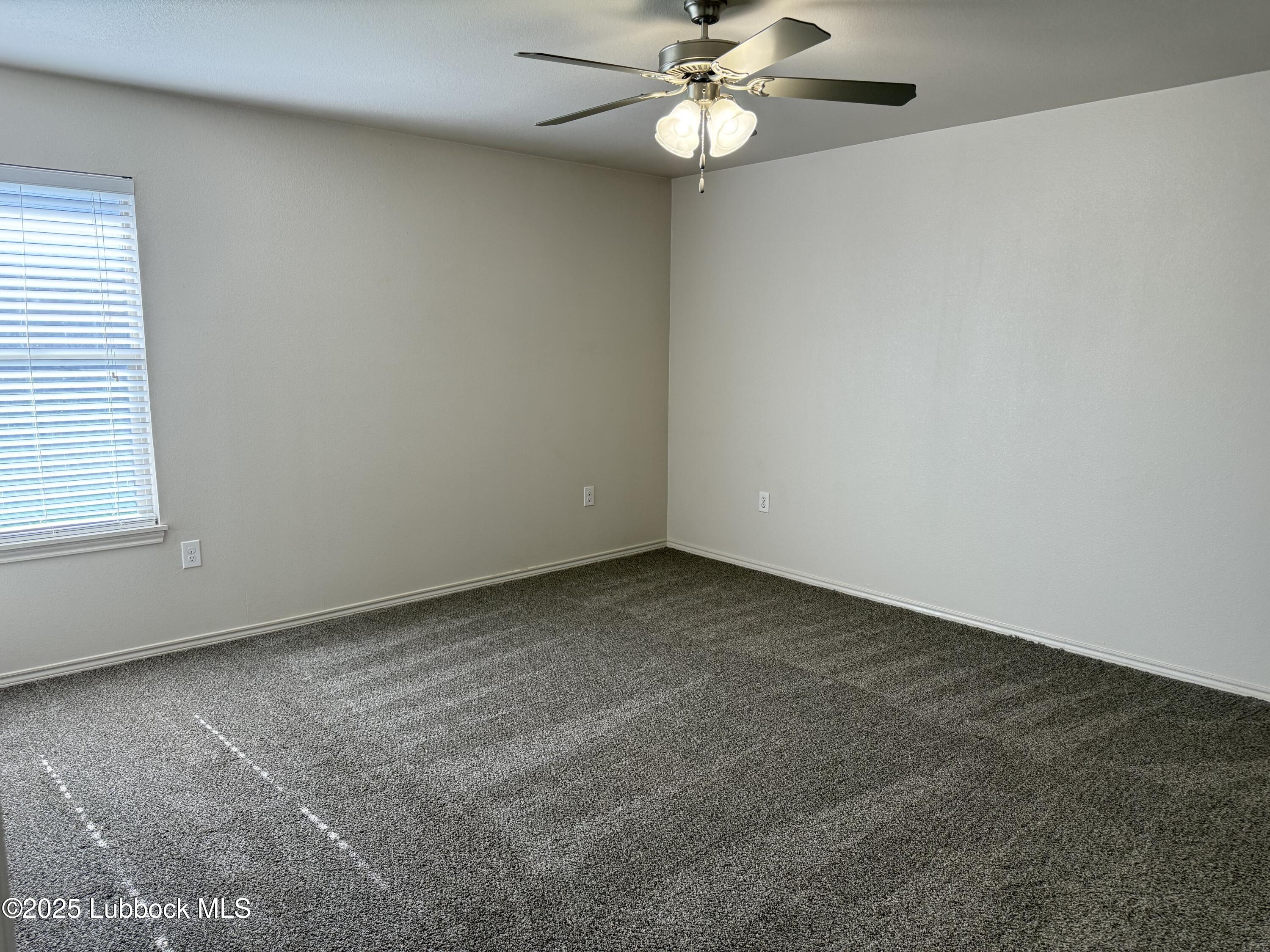 6711 Pontiac Avenue, Unit 12 Lubbock, TX 79424 - Photo 6 of 14 an empty room with a window and a fan