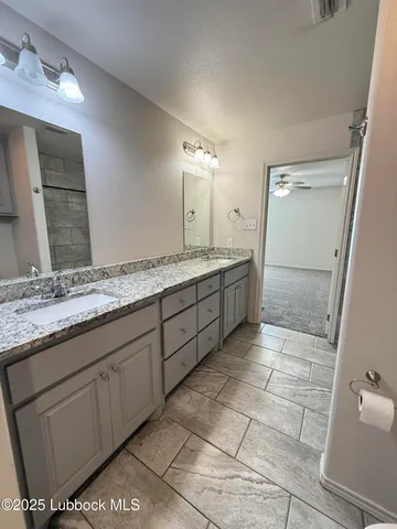 a spacious bathroom with a granite countertop sink a mirror and a