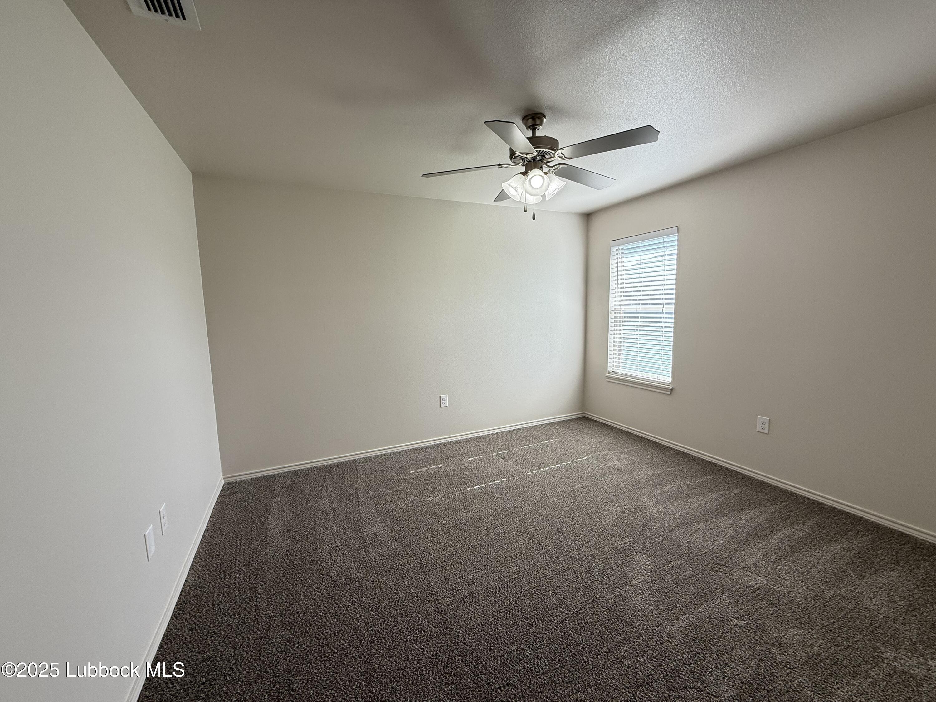 6711 Pontiac Avenue, Unit 12 Lubbock, TX 79424 - Photo 10 of 14 an empty room with windows and fan