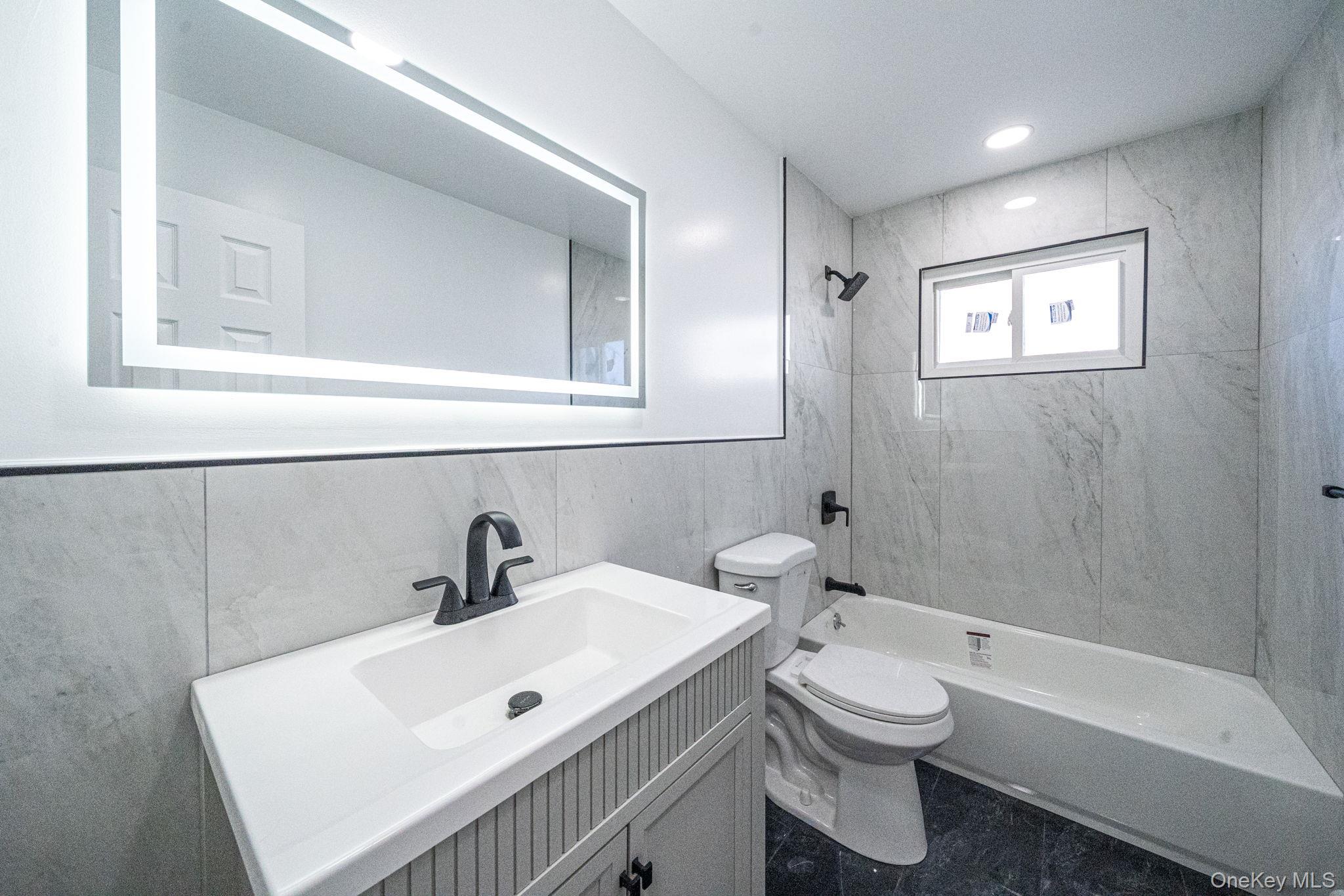 220-53 137th Road Queens, NY 11413 - Photo 12 of 41 a bathroom with a sink a toilet and shower